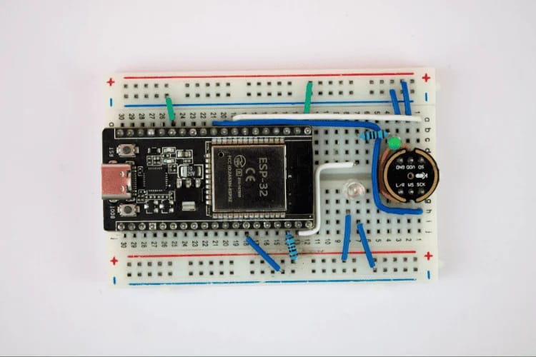 Esta imagen muestra el proyecto del microcontrolador esp32 que utiliza pulso de borde para reconocimiento de voz sobre fondo blanco; puede ver la placa y los dispositivos adjuntos allí.